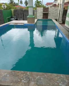 een zwembad met blauw water in een huis bij Port Dickson Holiday Home Villa in Port Dickson