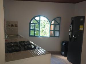a kitchen with a stove and a refrigerator and a window at Aldea Inmueble in Doradal