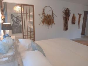 a bedroom with a white bed and a picture on the wall at Mamy Cherie in Rodrigues Island