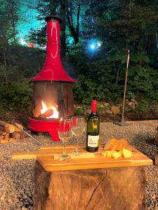 a table with two glasses and a bottle of wine at Kizuna Lodge & BBQ Centre in Hakuba