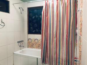 a bathroom with a tub and a shower curtain at Belle Ville in Sucre