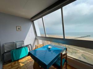 stół i krzesła w pokoju z dużym oknem w obiekcie Studio à St-Jean-de-Monts, avec parking, balcon et vue mer - FR-1-224C-201 w mieście Saint-Jean-de-Monts