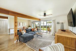 a living room with a couch and a tv at The Olena at Keauhou Bay in Kailua-Kona
