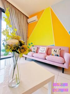 a living room with a couch and flowers in a vase at Legoland-Happy Wonder Suite,Elysia-8pax,100MBS in Nusajaya