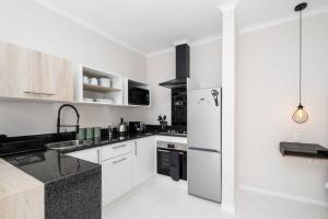 a kitchen with white cabinets and a stainless steel refrigerator at 31OnGambia in Johannesburg