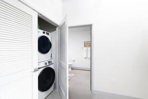 eine Waschküche mit Waschmaschine und Trockner neben einer Tür in der Unterkunft Spacious 1BR Near Fiserv with Rooftop, Gym, and Parking in Milwaukee