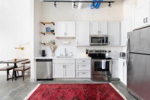 eine Küche mit weißen Schränken und einem roten Teppich in der Unterkunft Spacious 1BR Near Fiserv with Rooftop, Gym, and Parking in Milwaukee
