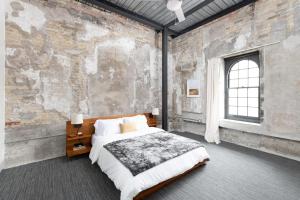um quarto com uma cama e uma parede de tijolos em Flexhome Brewery District 1BR Apt M10 - READ INFO em Milwaukee