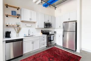 eine Küche mit weißen Schränken und Geräten aus Edelstahl in der Unterkunft Spacious 1BR Near Fiserv with Rooftop, Gym, and Parking in Milwaukee