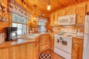 a kitchen with wooden cabinets and a white stove top oven at Kara's Cottage in Johnson City