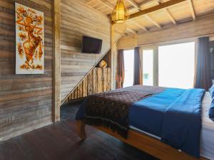 ein Schlafzimmer mit einem Bett und eine Treppe mit einem TV in der Unterkunft Lembo Lagoon Bungalows in Nusa Lembongan