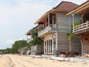a house on the beach next to a dirt road at Lembo Lagoon Bungalows in Nusa Lembongan