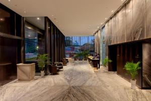 仰光Sayarsan Hotel Yangon的大堂,在桌子上坐着的人
