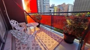 uma varanda com duas cadeiras e uma mesa e plantas em Departamento de los Boulevares em Córdova