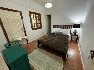 una camera con letto, tavolo e finestra di Casa Riacho Verde a Petrópolis