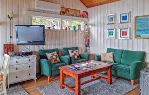 uma sala de estar com duas cadeiras verdes e uma televisão em 1 Bedroom Nice Home In Lyngdal em Lyngdal