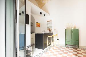 a kitchen with green cabinets and a checkered floor at Casa Fauno by Dimorra in Naples
