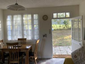 een eetkamer met een tafel en stoelen en een raam bij Nestling in a beautiful setting on the edge of the Forest of Tronçais in Couleuvre