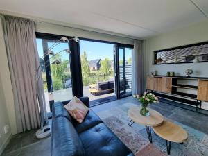 sala de estar con sofá y mesa en Luxurious detached water villa with jetty, en Balk