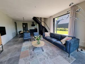 sala de estar con sofá azul y mesa en Luxurious detached water villa with jetty, en Balk