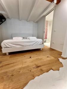 a bedroom with a bed and a wooden floor at La Finestra Sul Ghetto in Padova