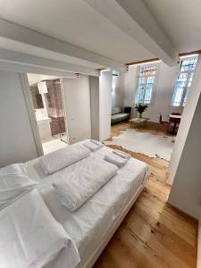 1 cama blanca grande en una habitación con ventanas en La Finestra Sul Ghetto, en Padua