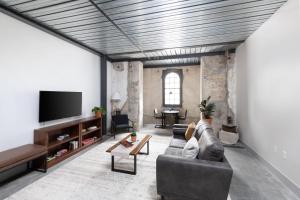 a living room with a couch and a tv at Cozy Double Queen Apartment Close to Fiserv with Parking in Milwaukee +21 photos