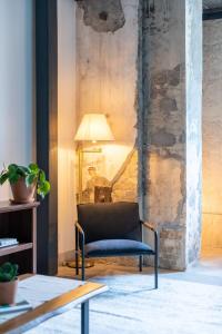 a chair in a living room with a lamp at Cozy Double Queen Apartment Close to Fiserv with Parking in Milwaukee