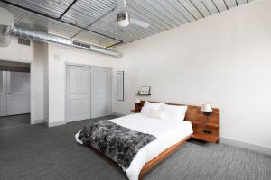 a bedroom with a large bed and white walls at Flexhome Brewery District 1BR Apt M1 - READ INFO in Milwaukee