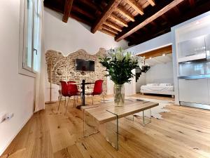 a living room with a table and red chairs at La Finestra Sul Ghetto in Padova