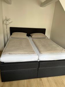 uma cama com duas almofadas num quarto em Citi Wohnung em Husum