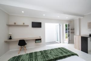 een witte woonkamer met een groen tapijt op de vloer bij 31OnGambia in Johannesburg