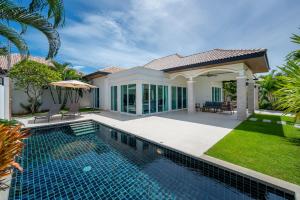 a swimming pool in front of a house at Orchid Paradise Homes OPV429 in Hua Hin