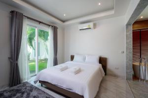 a bedroom with a white bed and a large window at Orchid Paradise Homes OPV429 in Hua Hin +18 photos