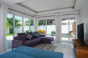 a living room with a couch and a tv at Orchid Paradise Homes OPV429 in Hua Hin