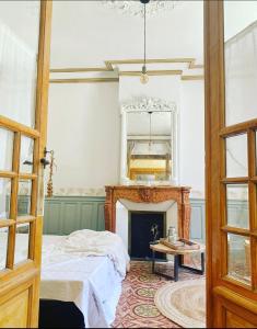 um quarto com uma cama, uma lareira e um espelho em Le Jardin em Aspiran