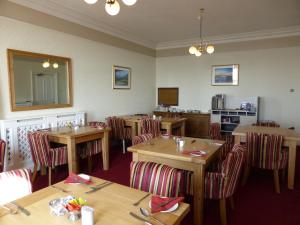 シースケールにあるBailey Ground Lodgeの木製のテーブルと椅子、鏡のあるレストラン