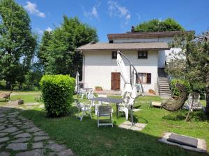 a house with a table and chairs in the yard at Appartamenti Bice Abetone in Abetone