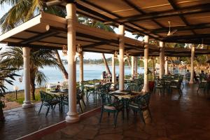 a restaurant with tables and chairs on the beach at Tamarind Village Hotel Apartments in Mombasa