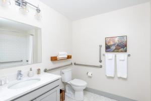 Un baño blanco con inodoro y lavabo. en Brewery District Luxe 1BR Near Fiserv with Parking, en Milwaukee 16 fotos más