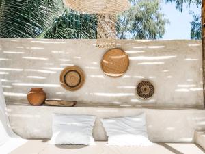 a bed with white pillows and hats on a wall at Villa Nakupenda with Pool and Ocean view in Kiwengwa