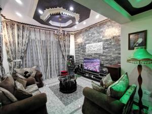 sala de estar con sofá y TV en Albert Suites & Apartments Entebbe, en Entebbe