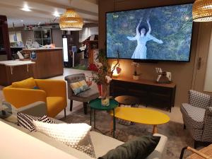 a living room with a large tv on the wall at Campanile Colmar - Parc des Expositions in Colmar