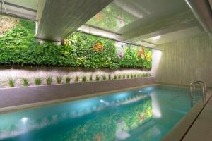 a swimming pool with a vertical garden on the wall at COCO-MAT Athens Jumelle in Athens