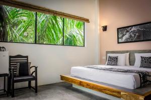 a bedroom with a bed and a large window at Haven Beach Hiri - Hiriketiya in Hiriketiya