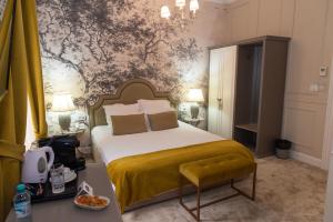 a bedroom with a large bed with a yellow blanket at Hotel Splendid 1900 in Craiova