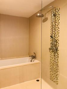 La salle de bains est pourvue d'une douche, d'une baignoire et d'un lavabo. dans l'établissement Paradiso Boutique Suites, à Bangkok