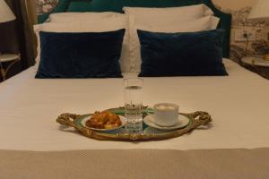 a tray with a cup and a plate of food on a bed at Hotel Splendid 1900 in Craiova