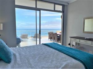 a bedroom with a bed and a view of the ocean at Beachfront @ Driftwood 6 Luxury Family Apartment in Ballito +19 photos