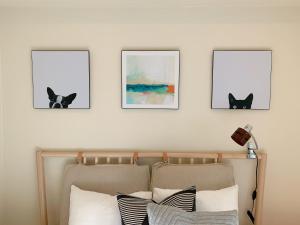 a bedroom with three pictures of black cats on the wall at Dash Living Tsukiji in Tokyo